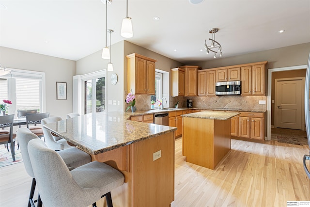 13303 Cuming St, Omaha, NE 68154 - kitchen with stainless steel appliances, a peninsula, a center island, light wood-style floors, and tasteful backsplash