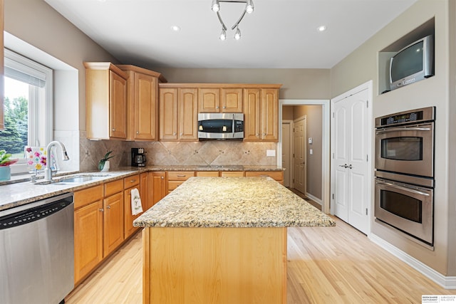 13303 Cuming St, Omaha, NE 68154 - kitchen with stainless steel appliances, a sink, light wood-style flooring, a kitchen island, and light stone counters