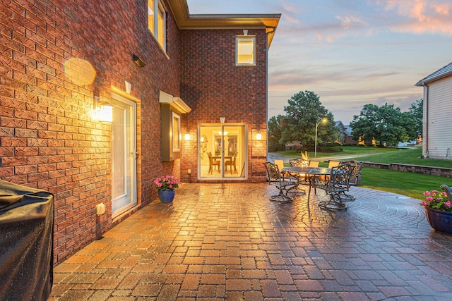 13303 Cuming St, Omaha, NE 68154 - patio terrace at dusk featuring a patio, outdoor dining space, and a yard