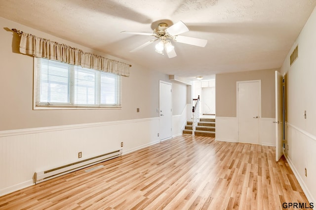 5617 S 93rd St, Omaha, NE 68127 - unfurnished room with a baseboard radiator, light wood-style flooring, wainscoting, ceiling fan, and stairway