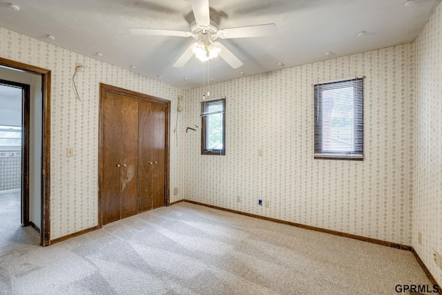 5617 S 93rd St, Omaha, NE 68127 - unfurnished bedroom featuring multiple windows, light colored carpet, a closet, and a ceiling fan