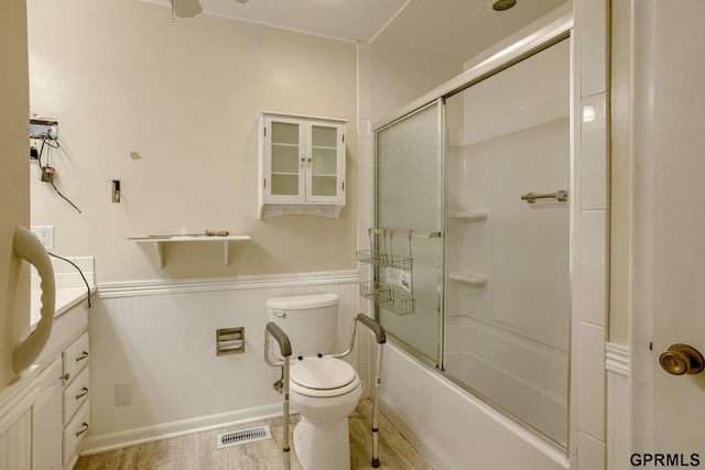5617 S 93rd St, Omaha, NE 68127 - bathroom featuring vanity, toilet, combined bath / shower with glass door, and a wainscoted wall