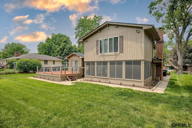 5617 S 93rd St, Omaha, NE 68127 - rear view of property featuring a deck, a sunroom, a chimney, and a lawn