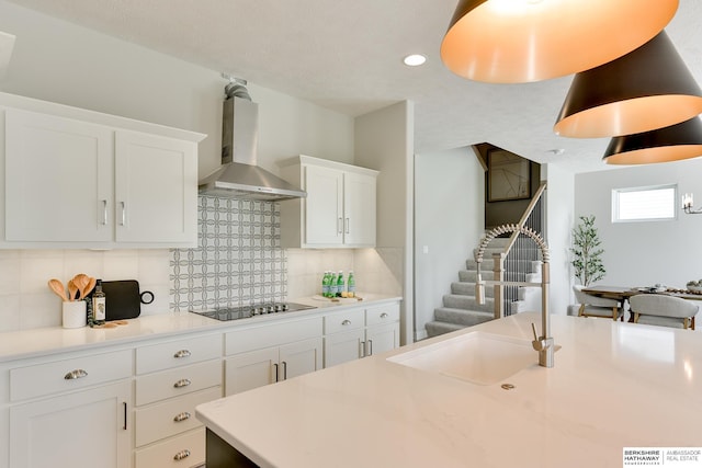 19920 Tyler St, Omaha, NE 68135 - kitchen featuring wall chimney exhaust hood, black electric stovetop, tasteful backsplash, white cabinets, and a sink