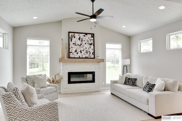 19920 Tyler St, Omaha, NE 68135 - living area featuring lofted ceiling, ceiling fan, a glass covered fireplace, recessed lighting, and a textured ceiling