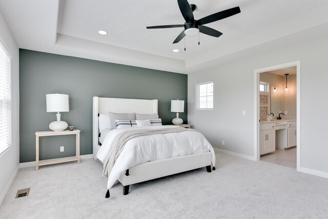 19920 Tyler St, Omaha, NE 68135 - bedroom featuring light colored carpet, a tray ceiling, baseboards, recessed lighting, and ensuite bath