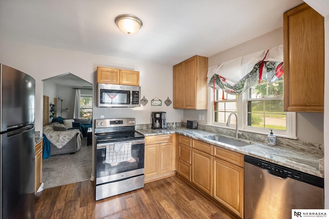 6021 Frederick St, Omaha, NE 68106 - kitchen featuring appliances with stainless steel finishes, a sink, light stone countertops, dark wood-style floors, and open floor plan