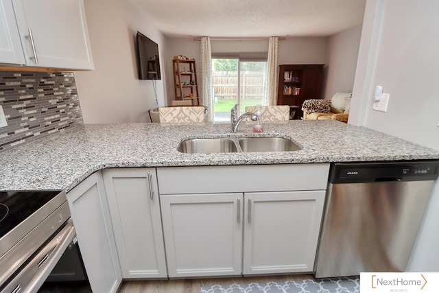 4115 N 45th Street Ct, Lincoln, NE 68504 - kitchen with dishwasher, a sink, backsplash, light stone countertops, and white cabinets