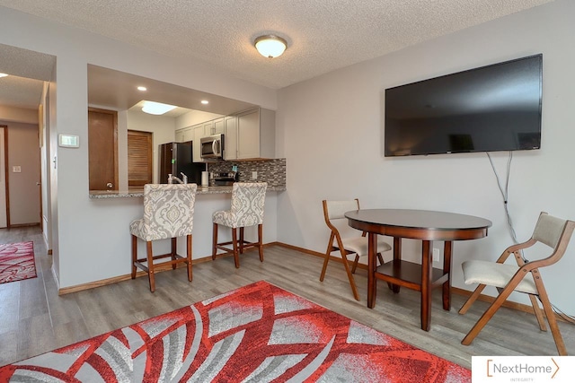 4115 N 45th Street Ct, Lincoln, NE 68504 - living area featuring light wood-style floors, baseboards, a textured ceiling, and recessed lighting