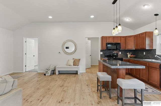 209 S Vine St, Mead, NE 68041 - kitchen featuring black appliances, vaulted ceiling, open floor plan, dark countertops, and tasteful backsplash