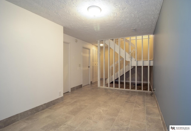 13220 Carpenter St, Omaha, NE 68138 - unfurnished room featuring a textured ceiling, stairs, and baseboards