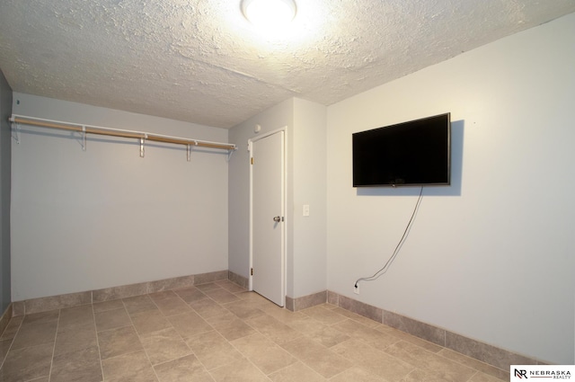 13220 Carpenter St, Omaha, NE 68138 - unfurnished bedroom featuring a textured ceiling, baseboards, and light tile patterned flooring