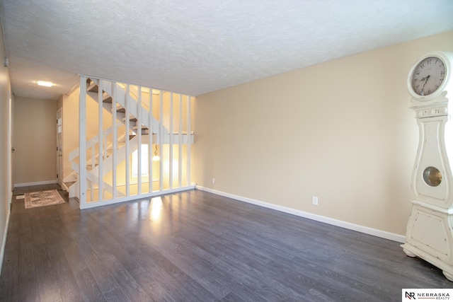 13220 Carpenter St, Omaha, NE 68138 - spare room featuring dark wood-style floors, baseboards, stairway, and a textured ceiling