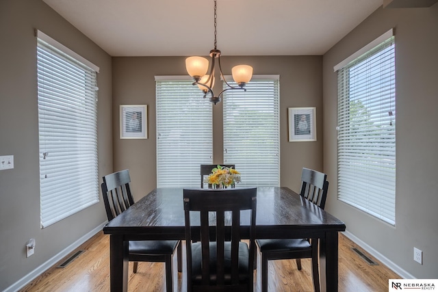 21313 Castlerock Ln, Gretna, NE 68028 - dining space featuring a chandelier, baseboards, and light wood-style flooring