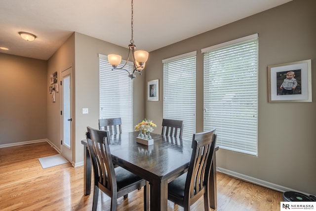 21313 Castlerock Ln, Gretna, NE 68028 - dining space with baseboards, light wood-style flooring, a chandelier, and plenty of natural light