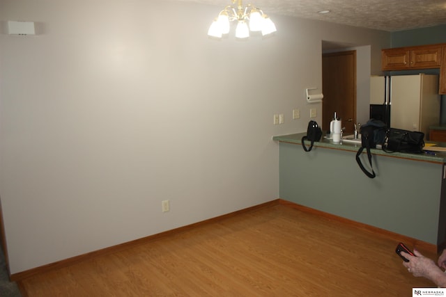 120 W Deer Ln, Plattsmouth, NE 68048 - unfurnished dining area featuring light wood finished floors, a chandelier, a textured ceiling, and baseboards