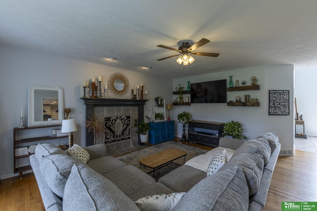 3902 Fox Ridge Dr, Bellevue, NE 68123 - living room featuring a ceiling fan, wood finished floors, a tiled fireplace, and baseboards