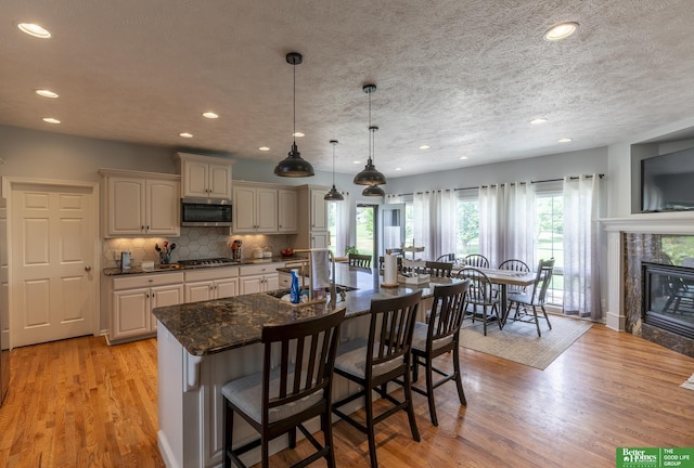 3902 Fox Ridge Dr, Bellevue, NE 68123 - kitchen with appliances with stainless steel finishes, a sink, a kitchen breakfast bar, recessed lighting, and light wood finished floors