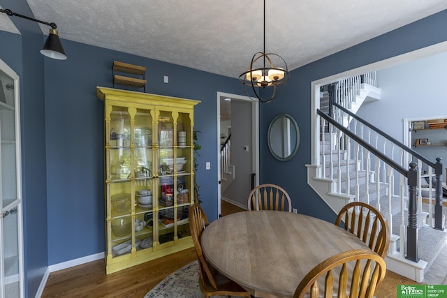 3902 Fox Ridge Dr, Bellevue, NE 68123 - dining room with stairway, wood finished floors, a chandelier, baseboards, and a textured ceiling