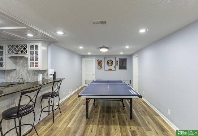 3902 Fox Ridge Dr, Bellevue, NE 68123 - game room featuring bar with sink, recessed lighting, light wood-style floors, and baseboards