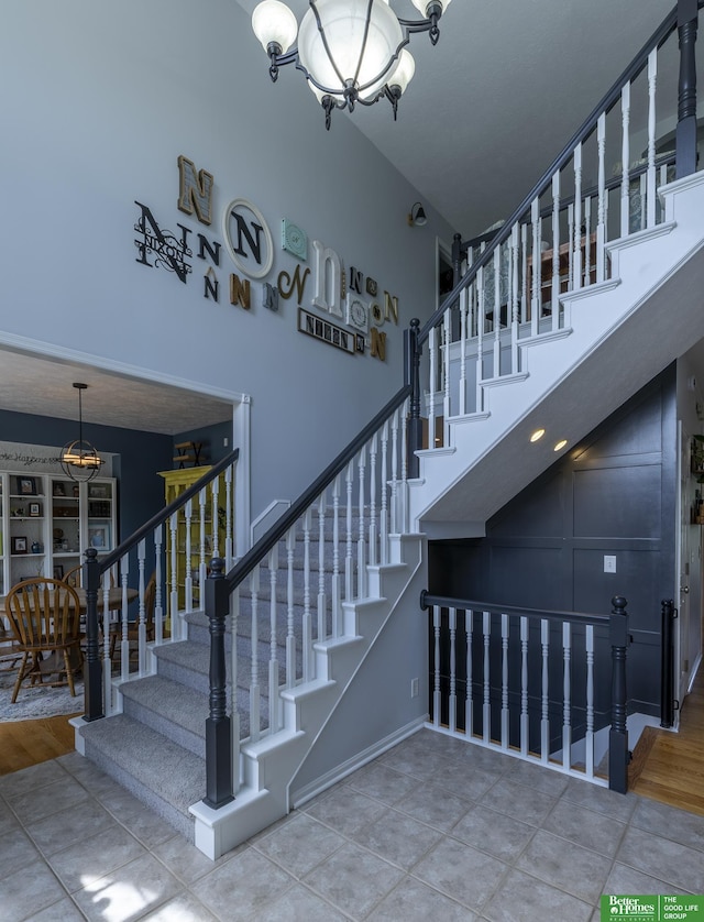 3902 Fox Ridge Dr, Bellevue, NE 68123 - staircase featuring a chandelier, a towering ceiling, and baseboards