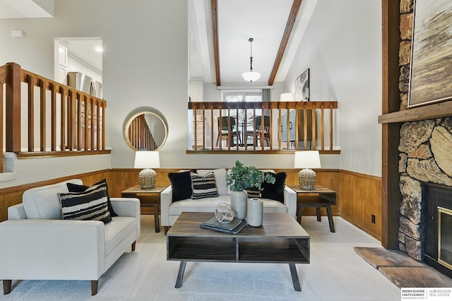 2615 Jack Pine St, Bellevue, NE 68123 - living area with wood walls, a wainscoted wall, beam ceiling, light carpet, and a stone fireplace