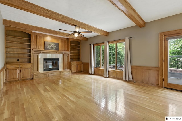 10428 Monroe St, Omaha, NE 68127 - unfurnished living room with beamed ceiling, light wood finished floors, wainscoting, a fireplace, and ceiling fan