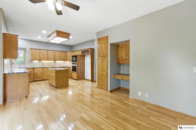 10428 Monroe St, Omaha, NE 68127 - kitchen with light wood-style floors, a kitchen island, oven, a sink, and ceiling fan