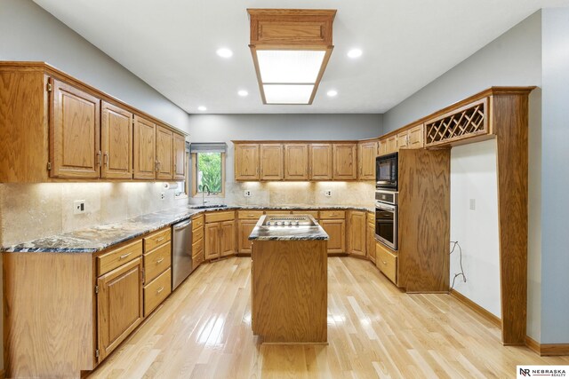 10428 Monroe St, Omaha, NE 68127 - kitchen featuring stainless steel appliances, a kitchen island, dark stone countertops, light wood-style flooring, and tasteful backsplash