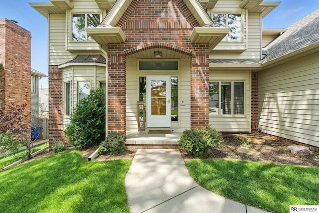 10428 Monroe St, Omaha, NE 68127 - view of exterior entry featuring brick siding and a shingled roof