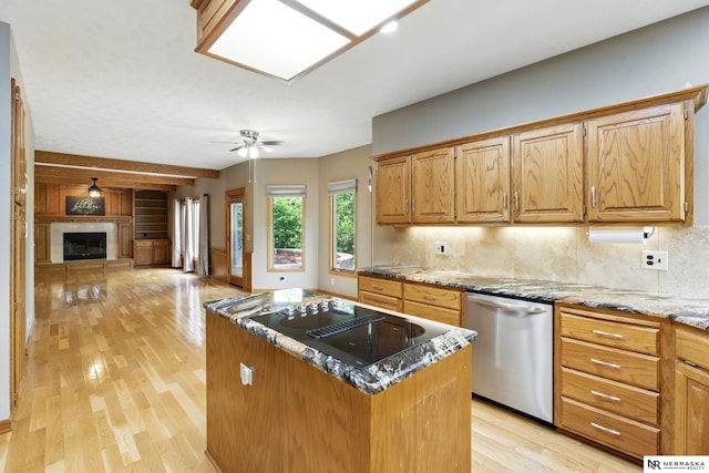 10428 Monroe St, Omaha, NE 68127 - kitchen with stainless steel dishwasher, black electric stovetop, a ceiling fan, light wood-style flooring, and tasteful backsplash
