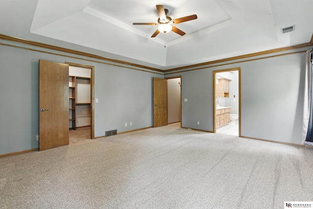 10428 Monroe St, Omaha, NE 68127 - unfurnished bedroom featuring a raised ceiling, connected bathroom, light carpet, and baseboards