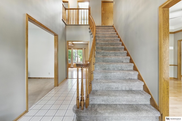 10428 Monroe St, Omaha, NE 68127 - stairway with baseboards, a high ceiling, and tile patterned floors