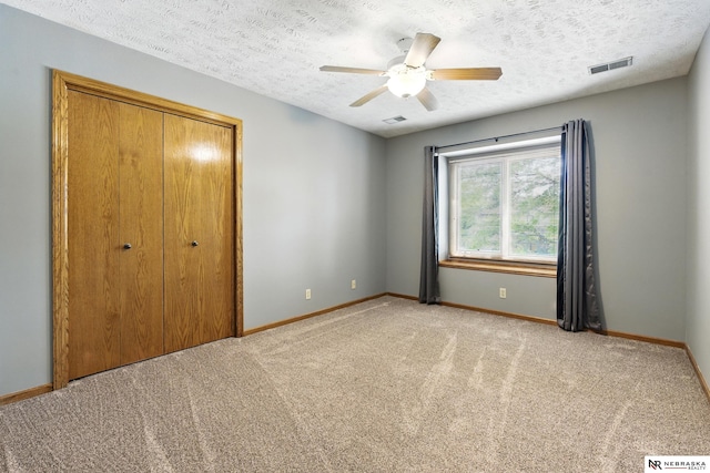 10428 Monroe St, Omaha, NE 68127 - unfurnished bedroom with a closet, light colored carpet, baseboards, a textured ceiling, and ceiling fan