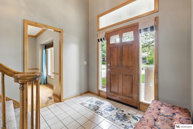 10428 Monroe St, Omaha, NE 68127 - foyer entrance with light tile patterned floors, stairs, and baseboards