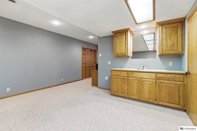 10428 Monroe St, Omaha, NE 68127 - kitchen with light colored carpet, recessed lighting, light countertops, baseboards, and brown cabinets