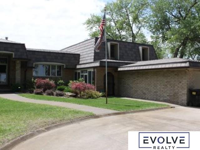 1599 S Main St Unit 7, Fremont, NE 68025 - view of home's exterior with mansard roof, a lawn, and brick siding