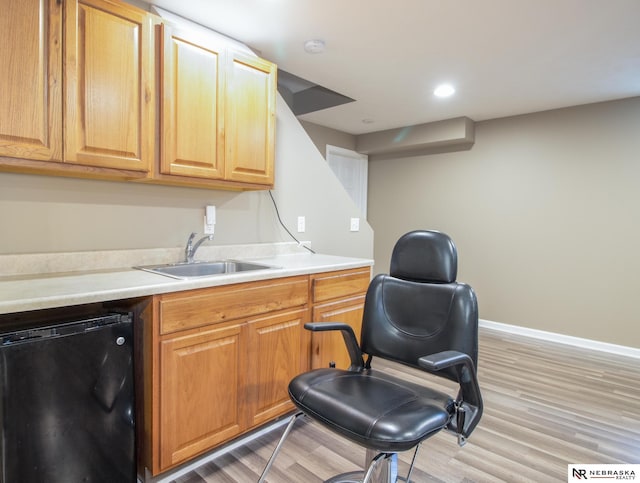 1715 Belford St, Lincoln, NE 68521 - kitchen with black dishwasher, a sink, light countertops, light wood-style floors, and baseboards