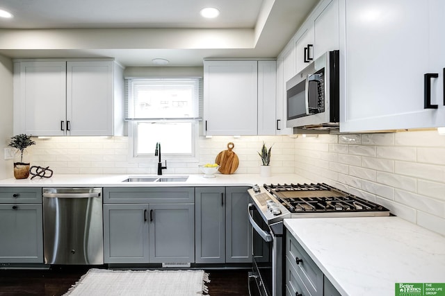 2833 S 107th St, Omaha, NE 68124 - kitchen with stainless steel appliances, a sink, decorative backsplash, gray cabinetry, and recessed lighting