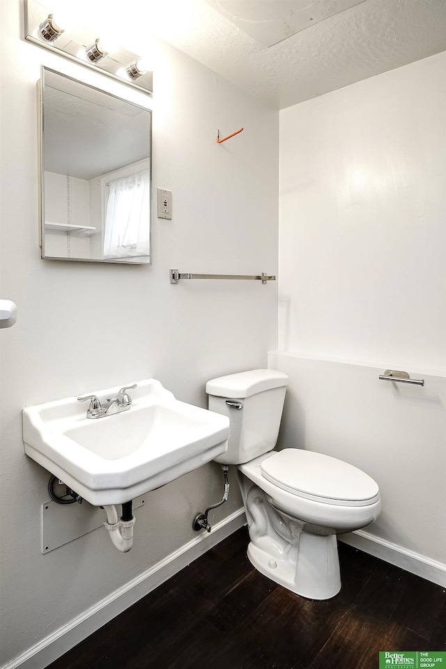 2833 S 107th St, Omaha, NE 68124 - bathroom featuring baseboards, wood finished floors, toilet, and a sink