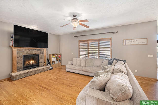 2231 Crystal Creek Dr, Papillion, NE 68046 - living room with ceiling fan, a fireplace, a textured ceiling, wood finished floors, and baseboards
