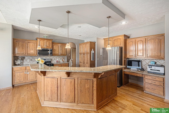 2231 Crystal Creek Dr, Papillion, NE 68046 - kitchen with stainless steel appliances, a breakfast bar area, light wood finished floors, and a textured ceiling