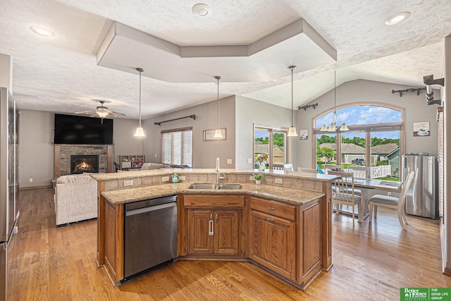 2231 Crystal Creek Dr, Papillion, NE 68046 - kitchen with stainless steel dishwasher, ceiling fan, brown cabinetry, a sink, and a textured ceiling