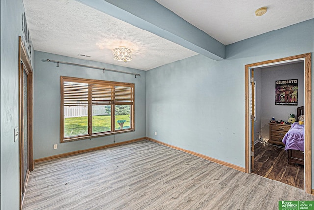 2231 Crystal Creek Dr, Papillion, NE 68046 - unfurnished room with wood finished floors, a chandelier, a textured ceiling, baseboards, and a smoke detector