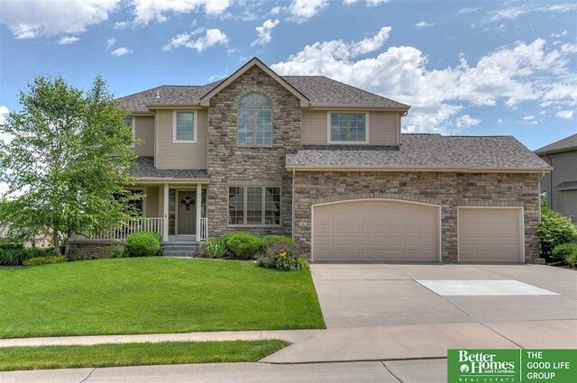 2231 Crystal Creek Dr, Papillion, NE 68046 - view of front of house featuring a front lawn, driveway, stone siding, and roof with shingles
