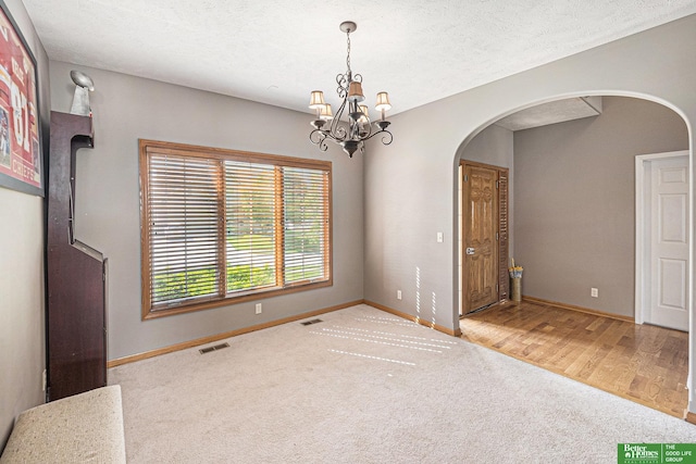 2231 Crystal Creek Dr, Papillion, NE 68046 - carpeted empty room with arched walkways, baseboards, and a chandelier
