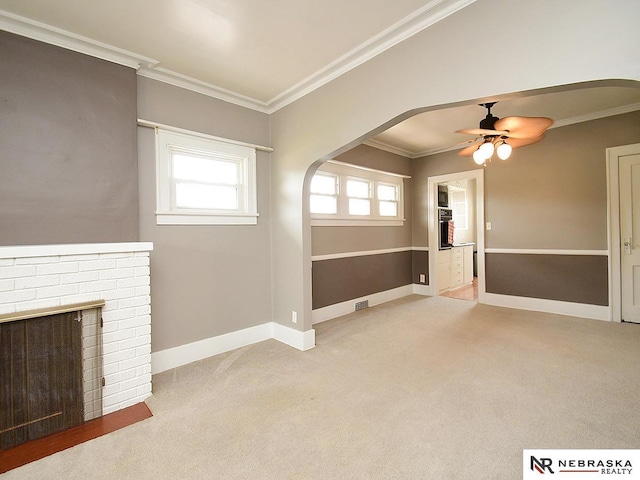 4540 S 41st St, Omaha, NE 68107 - unfurnished living room featuring a ceiling fan, ornamental molding, arched walkways, carpet floors, and healthy amount of natural light