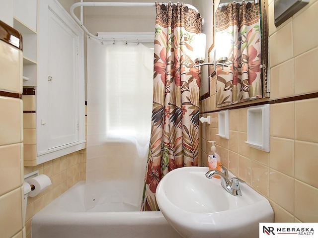 4540 S 41st St, Omaha, NE 68107 - full bath with a sink, tile walls, decorative backsplash, and shower / tub combo