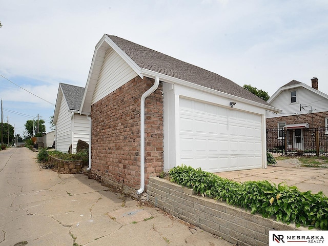 4540 S 41st St, Omaha, NE 68107 - view of side of home featuring a garage, roof with shingles, and stone siding