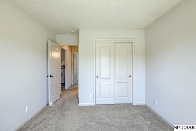 15930 Grebe St, Bennington, NE 68007 - unfurnished bedroom with light carpet, a closet, baseboards, and a textured ceiling
